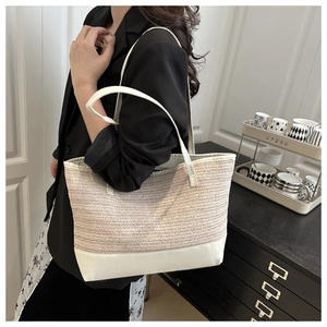 Detailed shot of beige woven tote bag with white leather trim and large interior capacity
