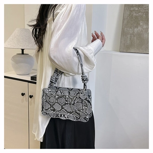 Détail du sac à bandoulière motif serpent avec texture et anse à nœud design