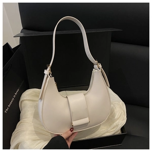 Detailed view of an off-white crescent shoulder bag displayed in an elegant gift box