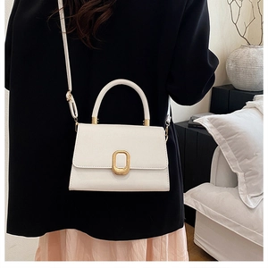 Detail of white leather crossbody bag with golden oval buckle and sleek hand strap