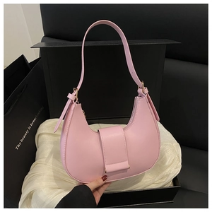 Detailed view of pink leather crescent underarm bag presented in a black gift box
