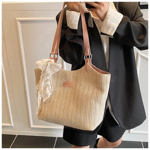 Detail of beige woven tote bag with pink straps and lace ribbon in a minimalist setting