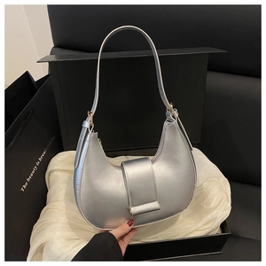 Silver metallic hobo bag with golden hardware placed in a luxury gift box with silk
