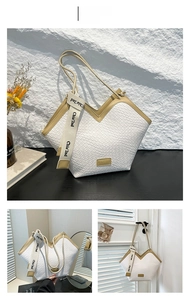 Détail de la texture tissée blanche et des garnitures kaki sur ce grand sac cabas