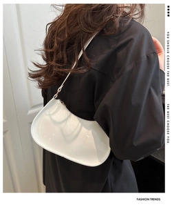 Sac sous le bras blanc brillant en forme de croissant porté à l'épaule, look chic