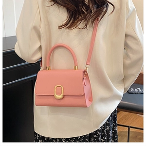 Detail of pink PU leather crossbody bag with golden oval buckle and elegant top handle