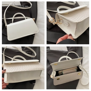 Detail views of white croc-embossed handbag showing hardware and interior space