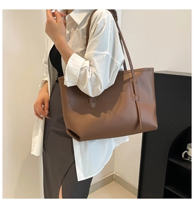 Grand sac cabas marron classique en cuir synthétique porté à l'épaule par un mannequin
