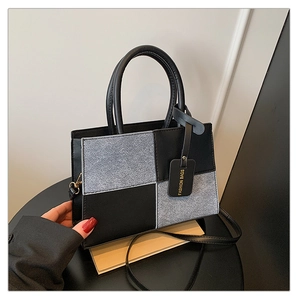 Detail of the black leather and grey wool texture patchwork on this square shoulder bag