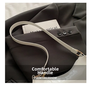 Détail du sac à bandoulière en cuir verni blanc avec fermoirs dorés et longue lanière