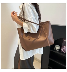 Side view of the brown leather tote bag showing spacious design and refined shoulder straps