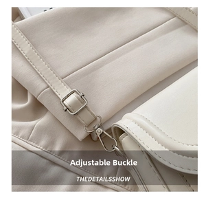 Detail of adjustable metal buckle and silver lobster clasp on a creamy white handbag