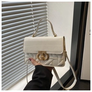 Close-up of beige quilted leather handbag featuring a golden metallic twist lock buckle