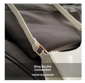 Vue macro d'un sac sous le bras en cuir verni blanc avec boucle en métal doré