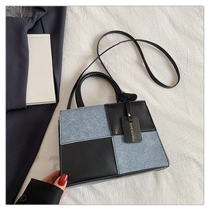Detailed top view of a patchwork crossbody bag with textured blue and black square panels