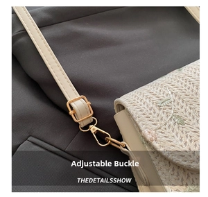 Close-up of adjustable strap buckle and floral embroidery on woven straw saddle bag
