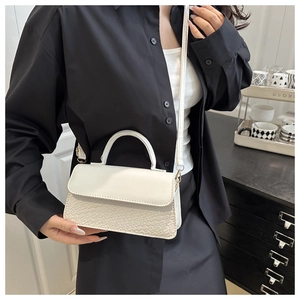 Detail of white crossbody bag featuring premium crocodile pattern and magnetic flap closure