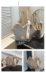 Detail of khaki houndstooth tote bag with slim handles and decorative branded ribbon