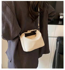 Close-up of cream woven crossbody bag showing textured faux leather and gold hardware
