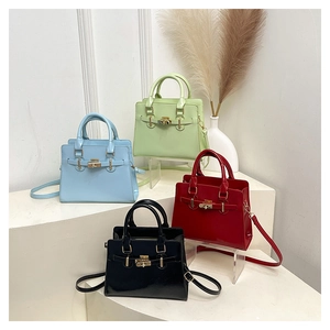 Detailed arrangement of high-gloss leather handbags in blue, green, red, and black colors