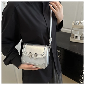 Detail of silver metallic leather handbag with a sleek metallic bow buckle detail
