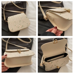 Detail view of woven saddle bag with floral embroidery and interior capacity