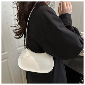 Sac hobo élégant en cuir verni blanc porté par un mannequin dans un style moderne