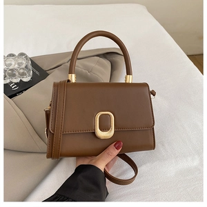 Close-up of brown crossbody bag featuring elegant gold metal ring buckle detail