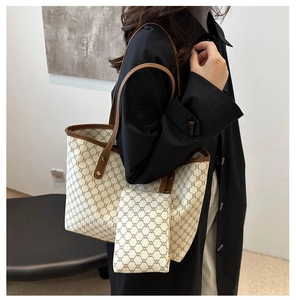 Détail du sac cabas vintage avec motif monogramme, poignée en cuir et mini pochette
