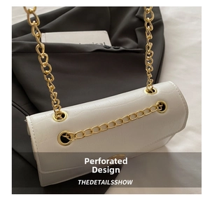 Detailed macro view of white crocodile pattern leather bag with gold chain strap design