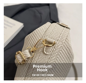 Detail showing the premium gold metal hook on the woven texture pillow bag side