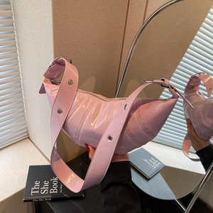 Pink patent leather dumpling bag with silver grommets and adjustable shoulder strap