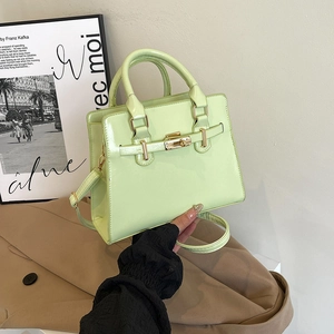 Chic mint green faux leather tote bag with gold buckle shown in a stylish fashion setting