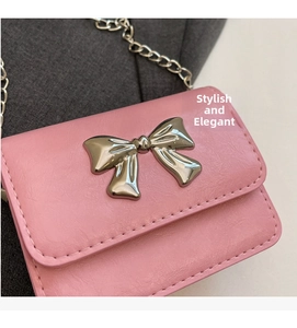 Detail of pink mini bag with silver bow ornament and metallic chain strap