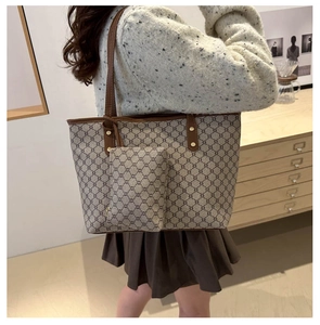 Photo lifestyle d'un grand sac cabas monogramme avec anses en cuir marron et pochette