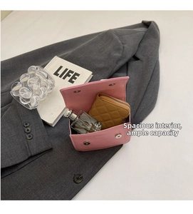 Detail view of pink crossbody bag interior capacity with wallet and perfume