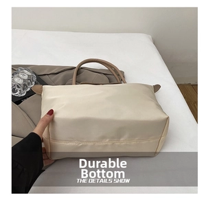 Gros plan détaillé du fond renforcé résistant à l'usure du sac fourre-tout en nylon beige