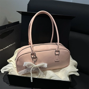 Pink glossy cylindrical handbag with pearl lace bow on silk lining in a gift box