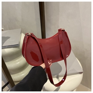 Gros plan du sac sous le bras en cuir verni rouge avec finition brillante et anneaux