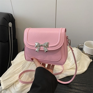 Pink crossbody bag with a silver metal bow and shiny PU leather finish