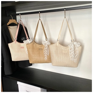 Detailed close-up of woven straw tote bags with lace bows and leather shoulder straps