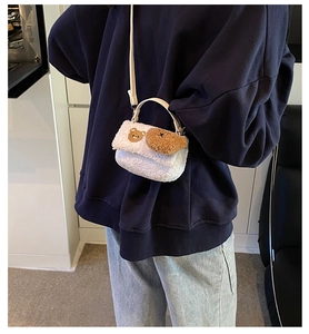 Détails d'un sac à bandoulière en peluche blanche avec broderie d'ours brun mignon