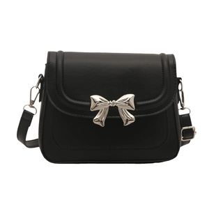 Fashionable black faux leather crossbody bag with a large silver metal bow decoration