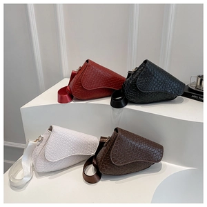 Close-up of saddle mini bags in four colors with woven texture and wide fabric straps