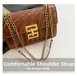 Detail of glossy brown crossbody bag featuring quilted texture and thick gold chain strap