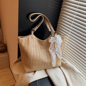 Large summer straw tote bag with brown leather handles and decorative white lace scarf
