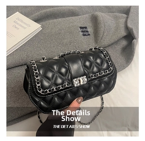 Detail of black quilted leather texture with classic silver metal chain and twist lock