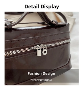 Macro shot of dark brown faux leather bag with silver brushed dual metal zipper pullers