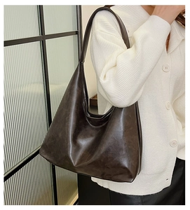 Detail of dark brown faux leather tote bag showing large capacity and soft texture