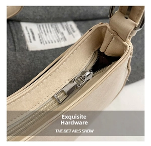 Detailed close-up of the silver rectangular metal zipper on the beige PU shoulder bag